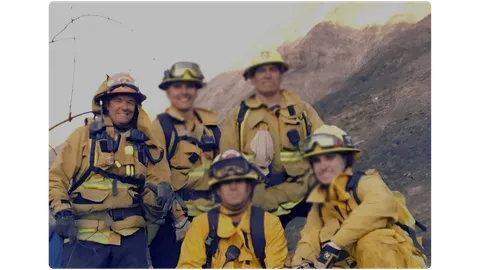 Wildfire hand crew posing on a burned hillside