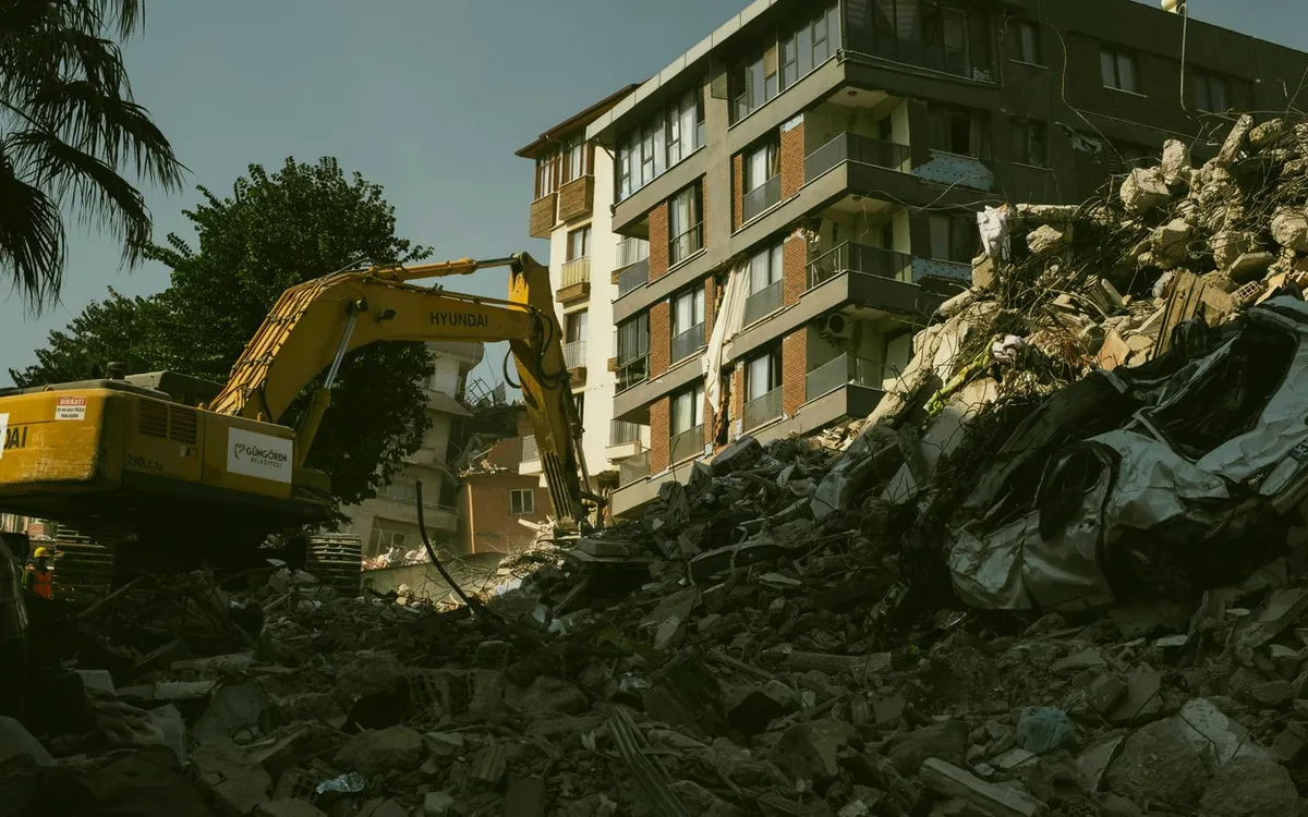 Excavator clearing the rubble of a collapsed building