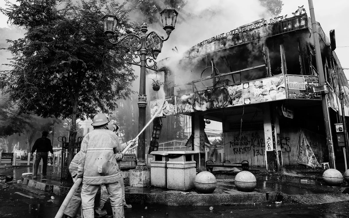 Firefighters hosing down a street fire
